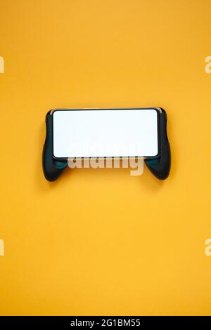 Joystick mobile phone, screen mockup Isolated on yellow background top view Stock Photo
