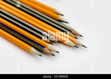 few sharply sharpened pencils of different color on the white table Stock Photo