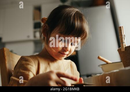 6 years old girl planting herbs at home Stock Photo