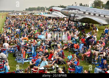 Thousands of aviation enthusiasts and pilots gather adjacent to the runway for the air show at the EAA Fly-In (AirVenture), Oshkosh, Wisconsin, USA Stock Photo