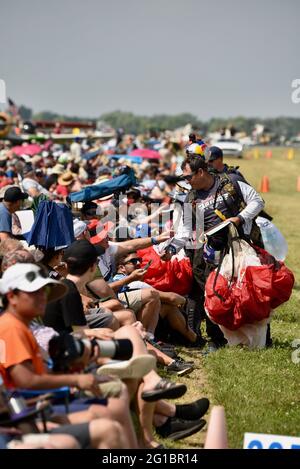 Thousands of aviation enthusiasts and pilots gather adjacent to the runway for the air show at the EAA Fly-In (AirVenture), Oshkosh, Wisconsin, USA Stock Photo