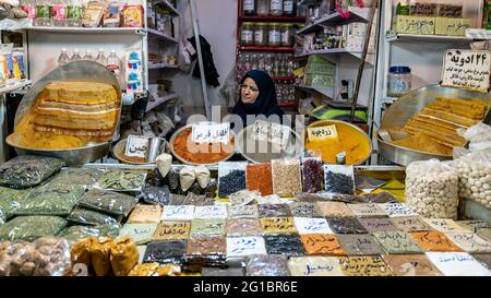 Isfahan, Iran - May 2019: Iranian woman selling various herbs and spices in Grand bazaar of Isfahan, historical market Stock Photo