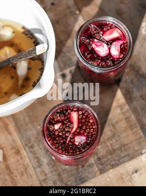 Pickles beets in brine with peppercorns and garlic. Rustic ambience, high contrast photography. Stock Photo