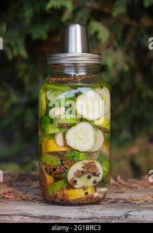 Old fashion pickles jar, with cucumbers in brine with spices in autumn ambience. Stock Photo