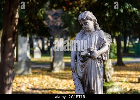 A statue of an angel on an ancient tombstone at the Ondrejský cintorín (St. Andrew's Cemetery) in Bratislava. Bratislava, Slovakia. 2020-11-07. Stock Photo
