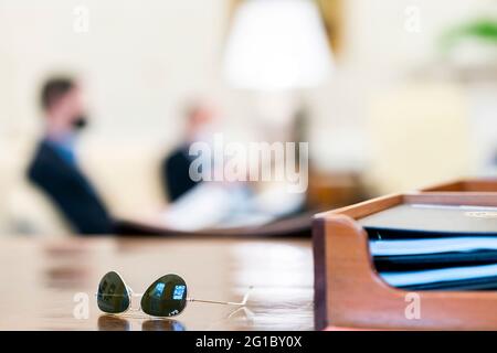 President Biden's sunglasses are seen on the Resolute Desk during an infrastructure meeting with White House staff in the Oval Office of the White House Sunday, April 11, 2021. (Official White House Photo by Cameron Smith) Stock Photo