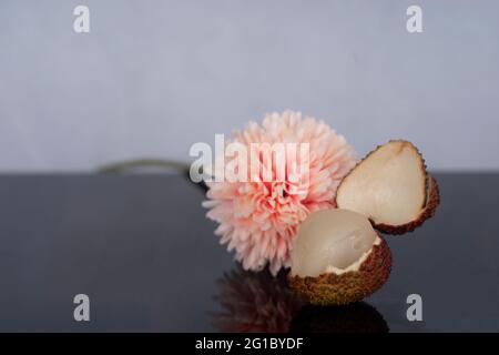 A single ripe and peeled green lychee. Selective focus points. Blurred background Stock Photo