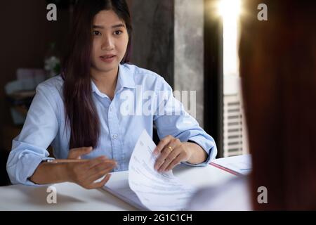 Businesswoman holding resume and talking to female candidate, during corporate meeting or job interview - business, career and placement concept. Stock Photo