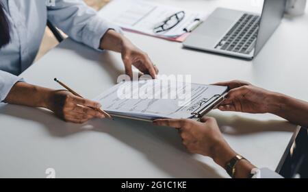 Businesswoman holding resume and talking to female candidate, during corporate meeting or job interview - business, career and placement concept. Stock Photo