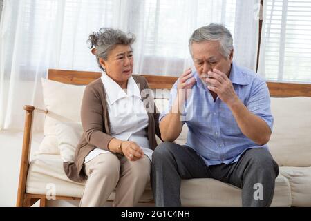 Elderly stroke, Asian elder suffer from stroke and powerful headache or brain attack and take care from his wife Stock Photo