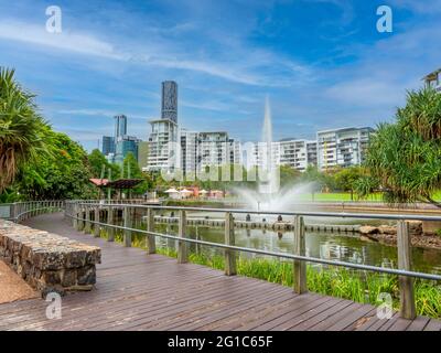 Park lands and apartment building at Roma Street in Brisbane, Australia. Fountain and lake, residential and office buildings in the background. Stock Photo