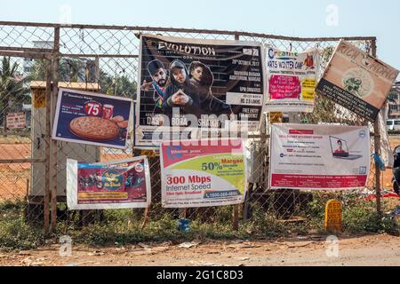Fence in Margao with advertising signage for businesses, promotions and services, Margao, Goa, India Stock Photo