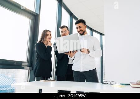Employees of the IT company show their boss the process of developing new software Stock Photo