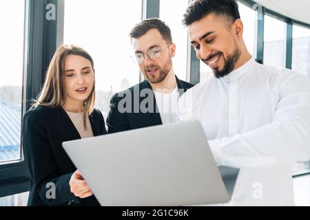 Group of multiracial employees of software company consider a new startup in a laptop Stock Photo