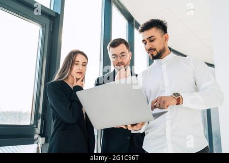 Office workers show company earnings reports on laptop to their boss Stock Photo