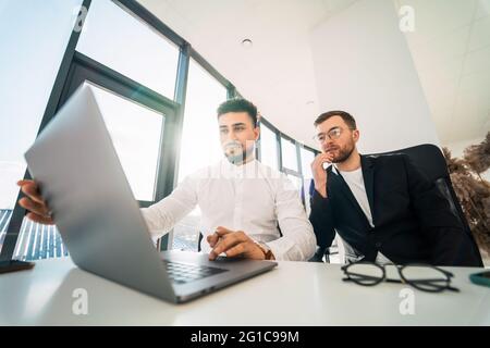 Two business partners are working on laptop Stock Photo