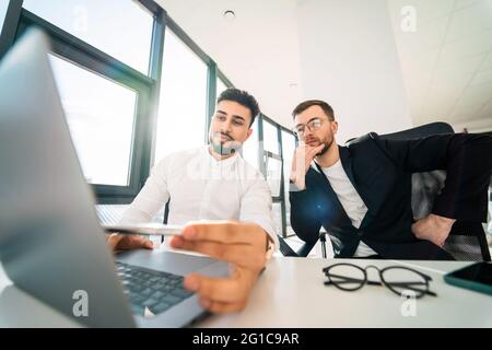 Two programmers are working on laptop on new project Stock Photo