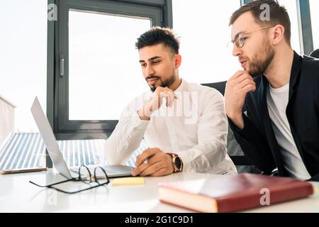 Two business men are thinking about project at laptop Stock Photo