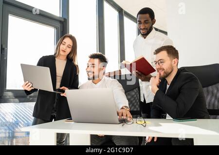 Multiracial business team working in the office at laptops on new startup Stock Photo