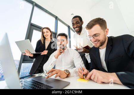 Young multiracial software developers working on laptop together on new project Stock Photo