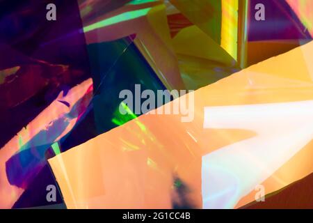 Multicolored holographic paper abstraction. Purple, yellow and green colors, futuristic retro style background. Stock Photo