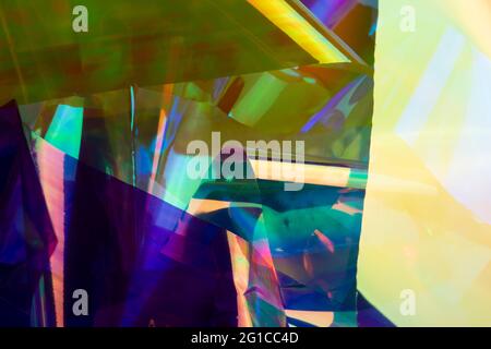 Multicolored holographic paper abstraction. Purple, yellow and green colors, futuristic retro style background. Stock Photo