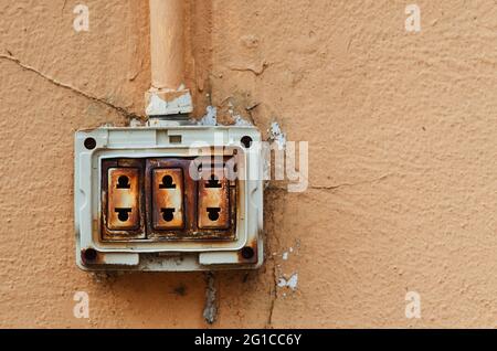 The dangerous old electric plug on the wall Stock Photo - Alamy