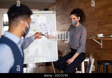 Business people making presentation in cafe, freelance work and coronavirus concept. Stock Photo