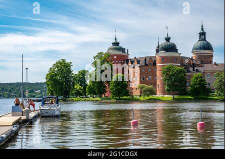Sunny summer day at Lake Mälaren on June 6th 2021 in idyllic small town Mariefred  on the National day of Sweden. Gripsholm Castle in the background. Stock Photo