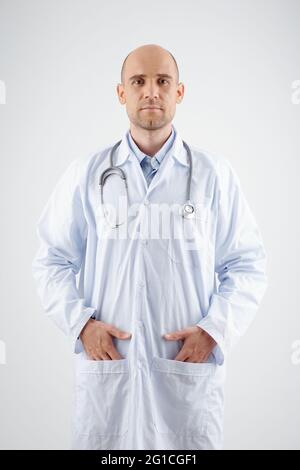 Portrait of serious doctor in white labcoat standing with hands in pockets Stock Photo