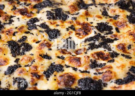 Close-up of pizza topped with with truffles and cheese. Macro shot of delicious products. Stock Photo