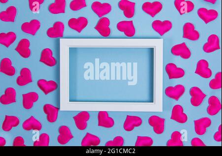 White frame with red hearts on blue background, copy space, valentine's day, love, invitation Stock Photo