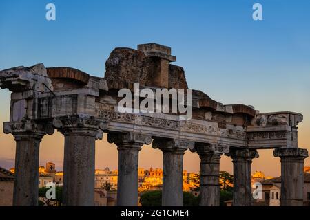 Temple of Saturn architectural details in Rome, Italy, closeup to entablature on Ionic columns at dusk against sunset sky. Ancient Roman monument dedi Stock Photo