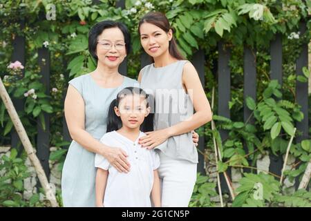 Three generation of one family: grandmother, mother and daughter standing outdoors Stock Photo