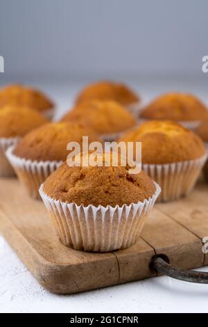 Biscuit muffins close-up. Sweet pastries. Party treat. Dessert on white table - homemade muffins. Portioned cupcakes. Simple muffin. Stock Photo