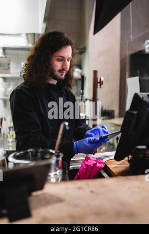 Young male waiter using digital tablet at restaurant Stock Photo