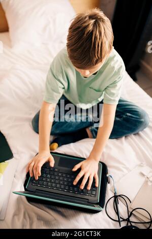 Boy using laptop while E-learning at home Stock Photo