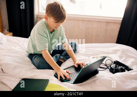 Boy E-learning through laptop at home Stock Photo