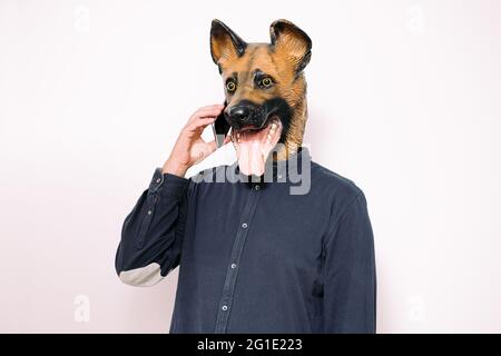 Young man in a latex dog head mask holding a weight scale on a pink  background Stock Photo - Alamy
