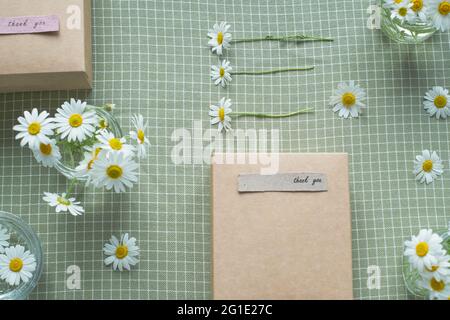 Gift decorated with chamomile flowers with words of gratitude. top view flat lay, eco friendly and zero waste packaging. High quality photo Stock Photo