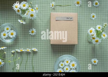 Gift decorated with chamomile flowers with words of gratitude. top view flat lay, eco friendly and zero waste packaging. High quality photo Stock Photo