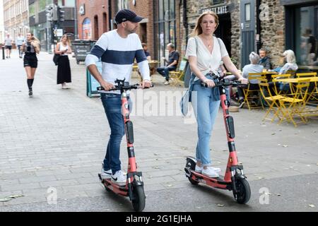Young people riding Voi e-scooters in Bristol, UK. Stock Photo