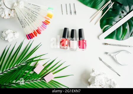 Tools of manicure set on white background as frame. Flat lay, nail polish in center. Stock Photo