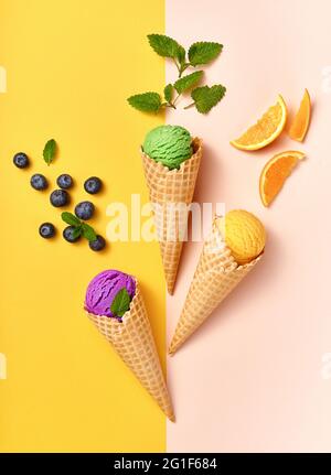 Assorted of ice cream in cones on white background. Colorful set of ice cream of different flavours. Ice cream isolated with nuts, fruits and berries. Stock Photo