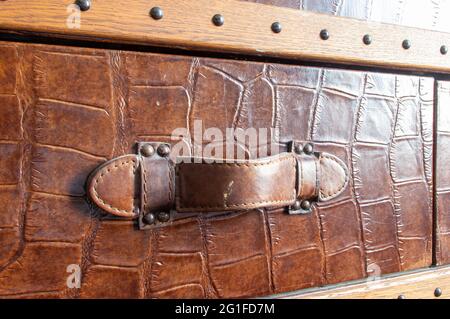 Extreme close-up of handle of steamer trunk covered with embossed leather and rivets Stock Photo