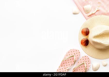 Flat lay of summer beach accessories isolated on white. Sraw hat with sunglasses and flip flops Stock Photo