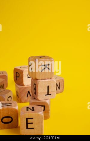 Wooden letter dices alphabet on yellow background Stock Photo