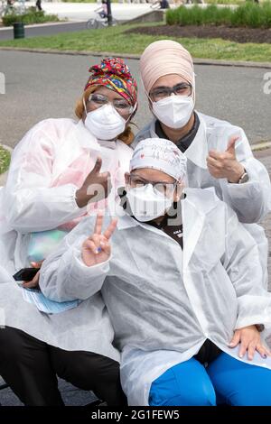 DIVERSITY. A Jamaican, Indian & South American nurse pose for a photo at a Covid vaccination site in Flushing Meadows Corona Park in Queens, New York . Stock Photo