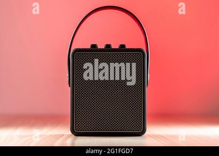 Black modern bluetooth loudspeaker on a reddish background Stock Photo