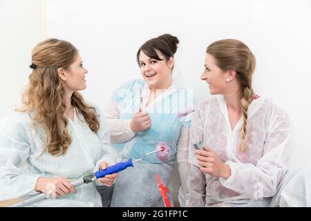 Portrait of happy female decorators holding painting equipment in hand Stock Photo